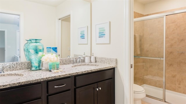 bathroom featuring vanity, toilet, and a shower with shower door