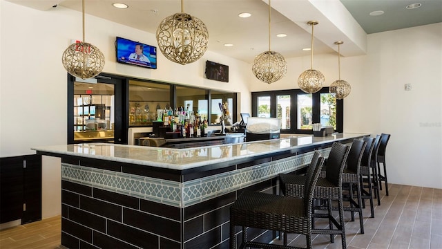 bar featuring wood-type flooring and hanging light fixtures