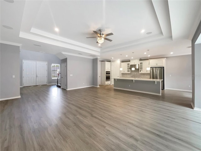 unfurnished living room featuring dark hardwood / wood-style flooring and a raised ceiling