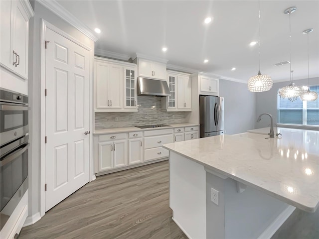 kitchen featuring light stone countertops, hanging light fixtures, stainless steel appliances, tasteful backsplash, and white cabinets