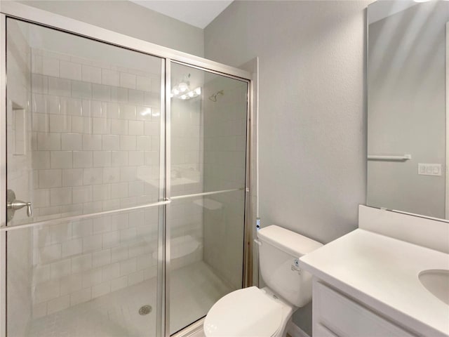 bathroom featuring vanity, toilet, and a shower with door