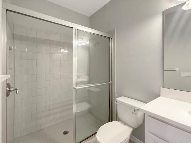 bathroom featuring vanity, toilet, and a shower with shower door