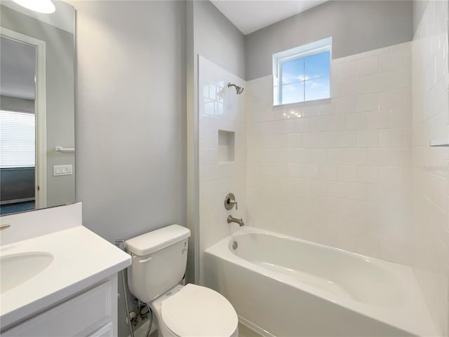 full bathroom featuring tiled shower / bath combo, toilet, and vanity