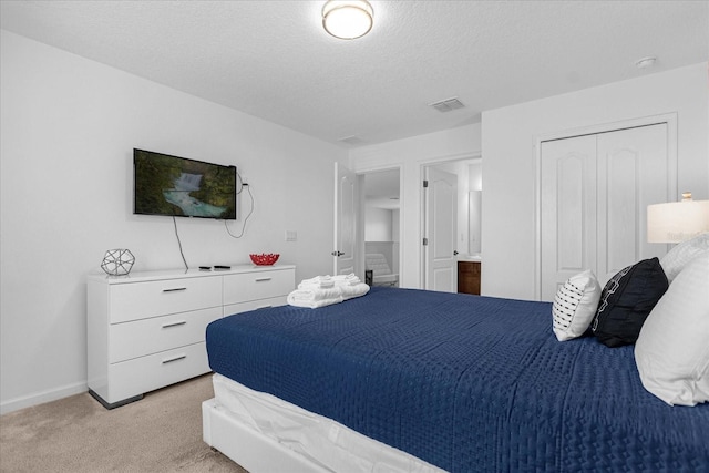 carpeted bedroom with a closet and a textured ceiling