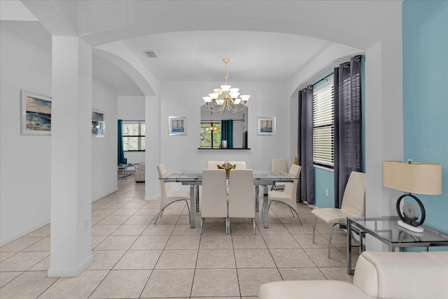 tiled dining room featuring a notable chandelier