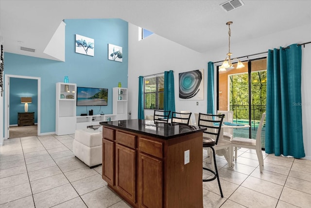 kitchen with a kitchen island, a chandelier, hanging light fixtures, and light tile flooring