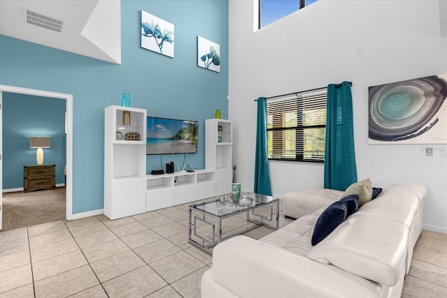 living room featuring a towering ceiling and light colored carpet