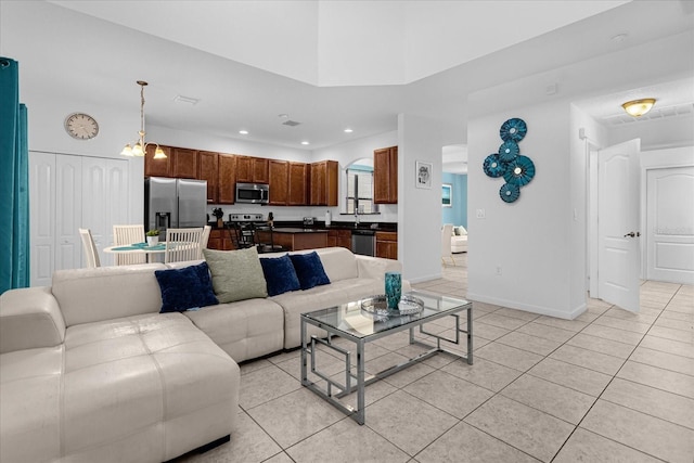 living room with light tile floors and an inviting chandelier