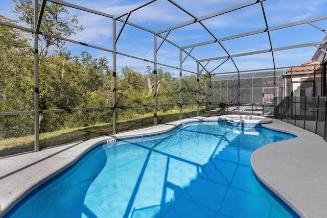 view of swimming pool with an in ground hot tub, glass enclosure, and a patio