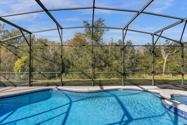 view of swimming pool featuring glass enclosure