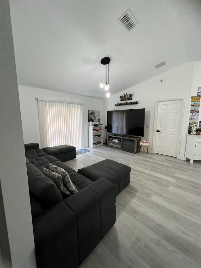 living room featuring light hardwood / wood-style flooring and vaulted ceiling