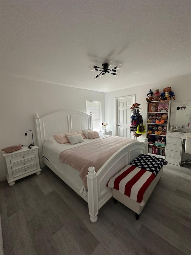 bedroom featuring ceiling fan, hardwood / wood-style floors, and a textured ceiling