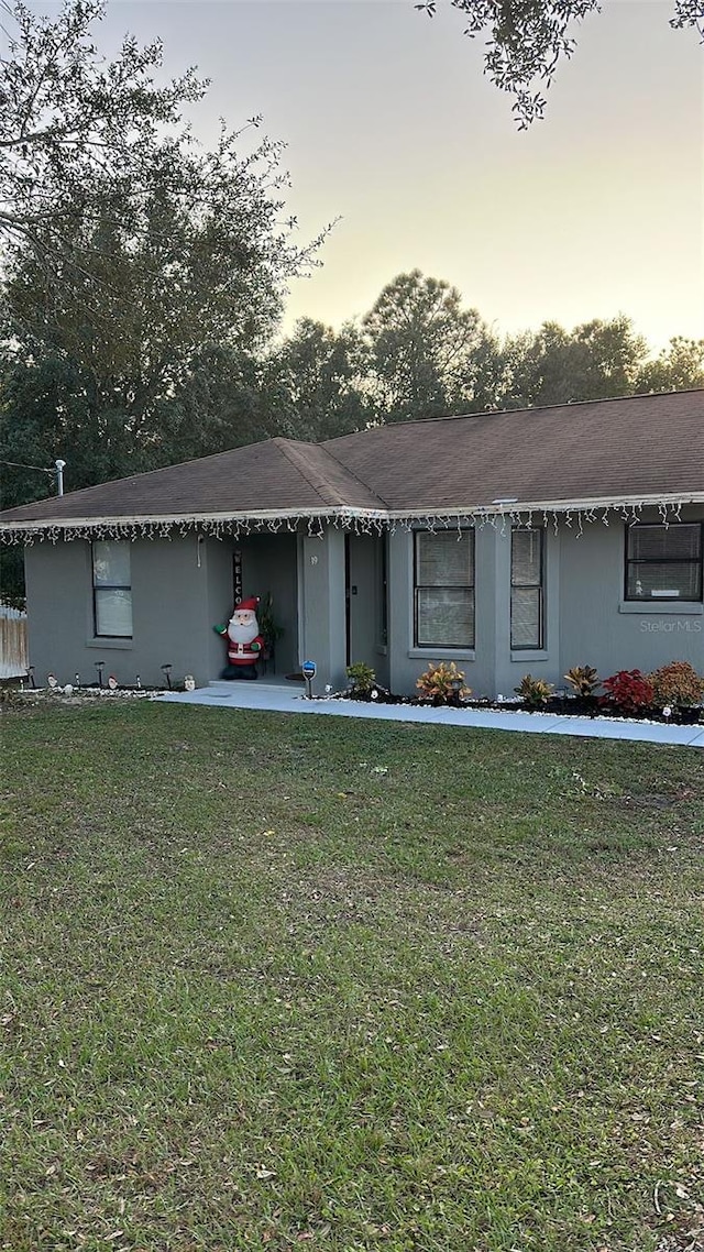 single story home with a lawn