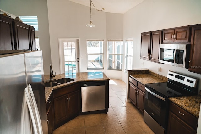 kitchen with stainless steel appliances, hanging light fixtures, sink, and dark brown cabinets