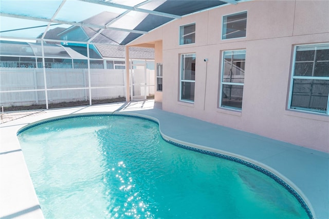 view of swimming pool featuring a lanai and a patio area