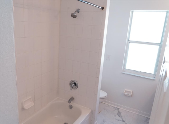 bathroom featuring tiled shower / bath and toilet