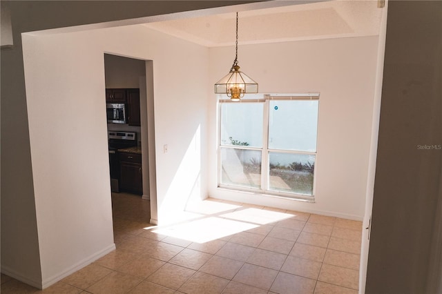 unfurnished dining area with light tile patterned flooring and an inviting chandelier