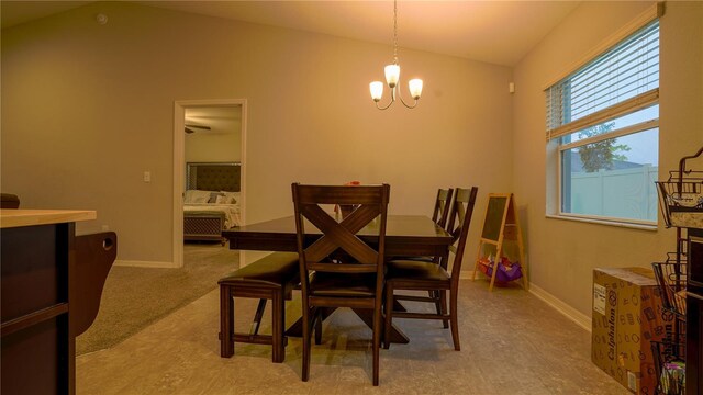 dining area featuring baseboards, vaulted ceiling, and a notable chandelier