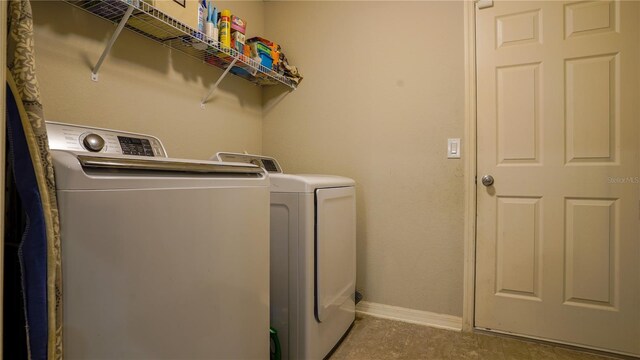 laundry area featuring laundry area, baseboards, and washing machine and clothes dryer