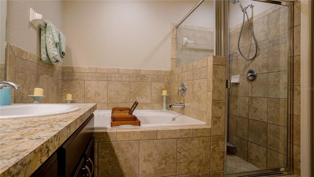 bathroom featuring a garden tub, a shower stall, and vanity