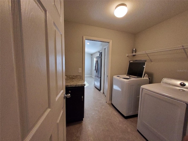 washroom with light wood-type flooring and washing machine and dryer