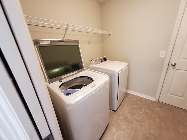 clothes washing area featuring laundry area, baseboards, and separate washer and dryer