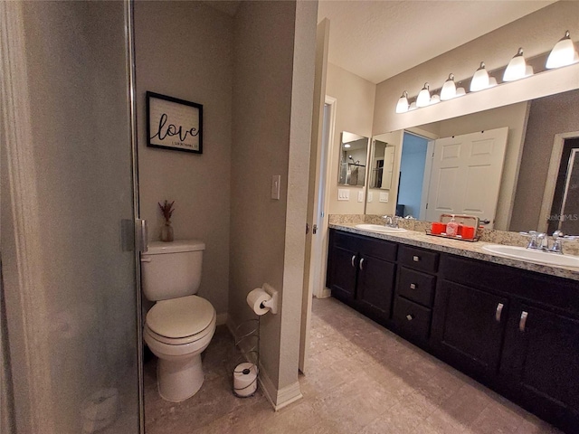 full bath with double vanity, a sink, toilet, and baseboards