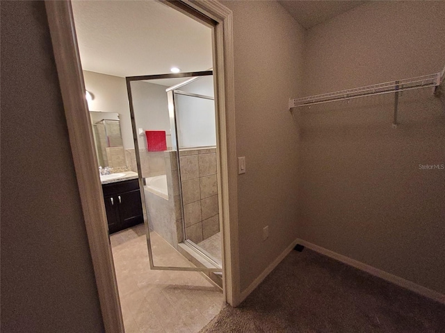 full bath with a bathing tub, a shower stall, vanity, and baseboards