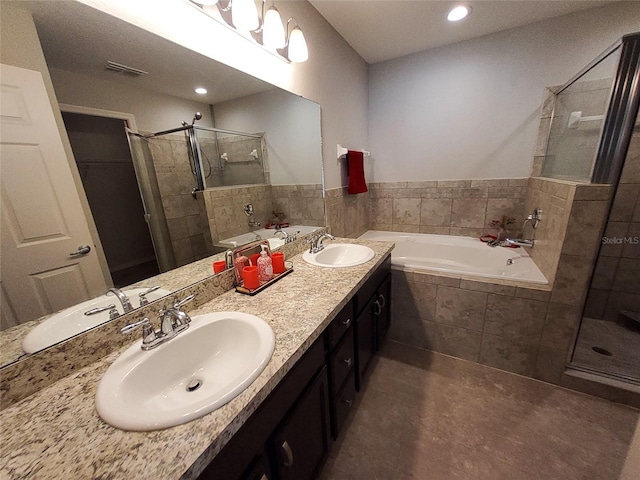 bathroom with a stall shower, visible vents, and a sink