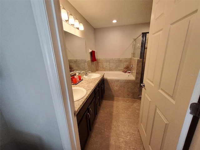 full bath with double vanity, a garden tub, a sink, and a stall shower