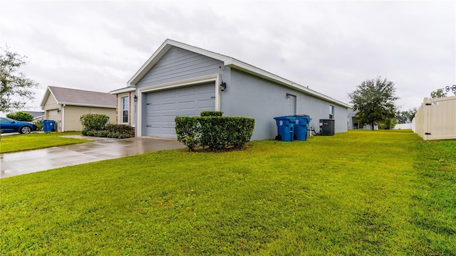 view of property exterior featuring central air condition unit, a garage, driveway, a lawn, and stucco siding