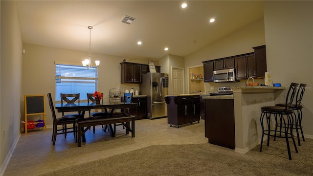 kitchen with a breakfast bar area, visible vents, dark brown cabinets, appliances with stainless steel finishes, and light countertops