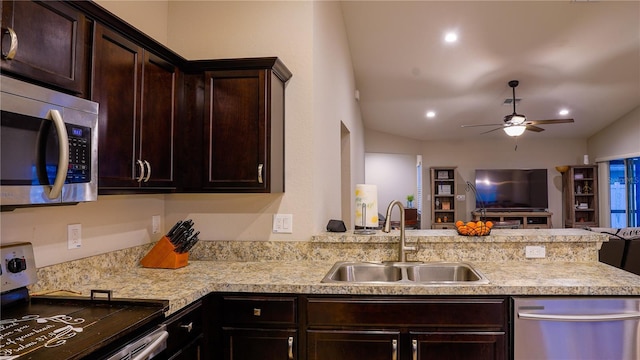 kitchen featuring stainless steel appliances, a peninsula, a sink, open floor plan, and light countertops