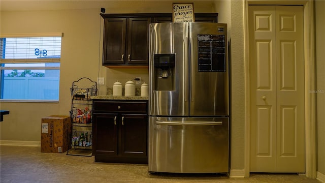 kitchen with baseboards, dark brown cabinets, and stainless steel fridge with ice dispenser