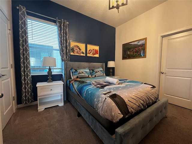 bedroom featuring a textured ceiling and dark colored carpet