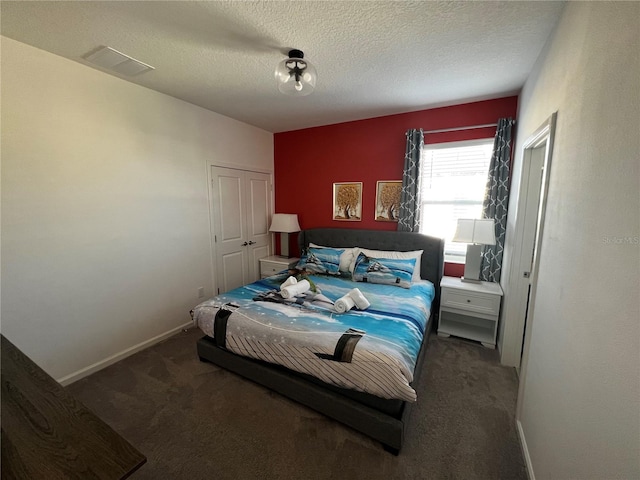 bedroom with a textured ceiling, carpet, and a closet