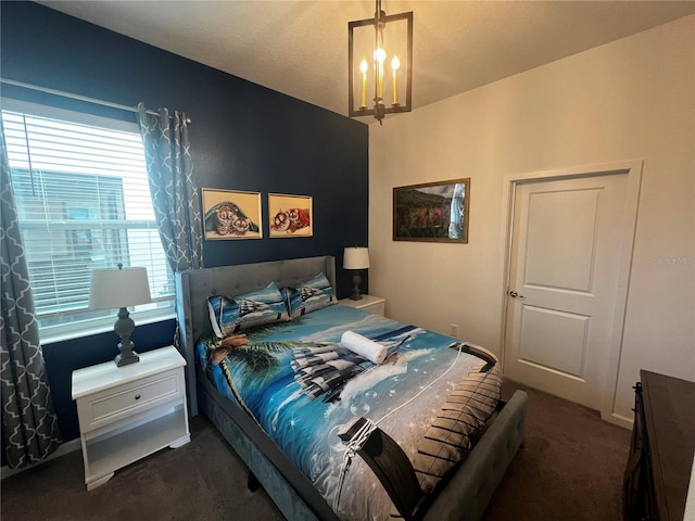 bedroom with dark colored carpet and a chandelier