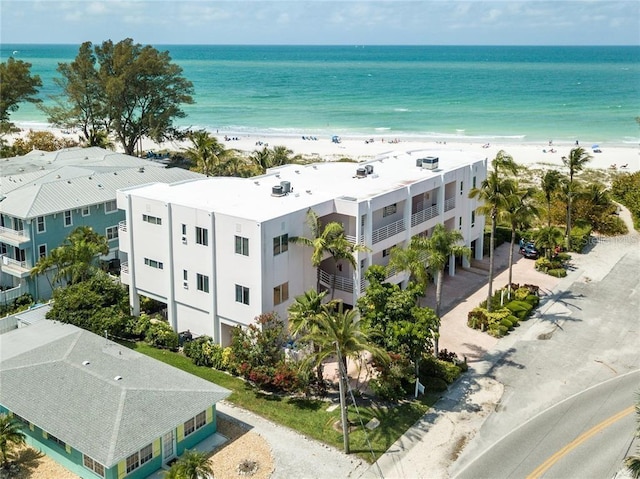 birds eye view of property with a water view and a beach view