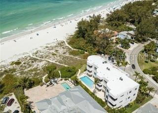 birds eye view of property featuring a beach view and a water view