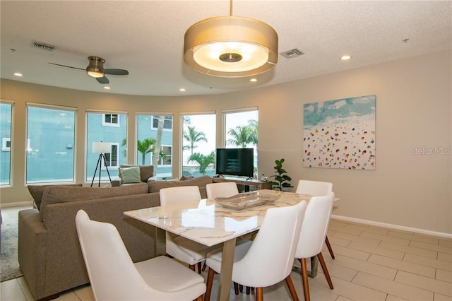 dining area with light tile patterned flooring, a textured ceiling, and ceiling fan