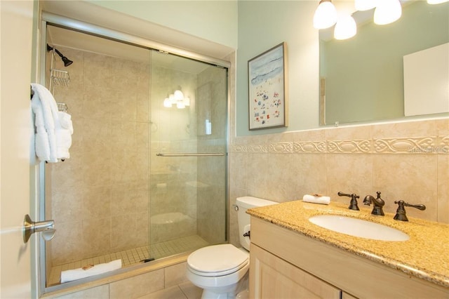 bathroom featuring tile walls, toilet, vanity, walk in shower, and tasteful backsplash