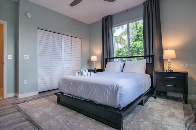 bedroom with ceiling fan, a closet, and light hardwood / wood-style floors