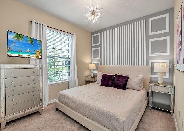 carpeted bedroom with an inviting chandelier