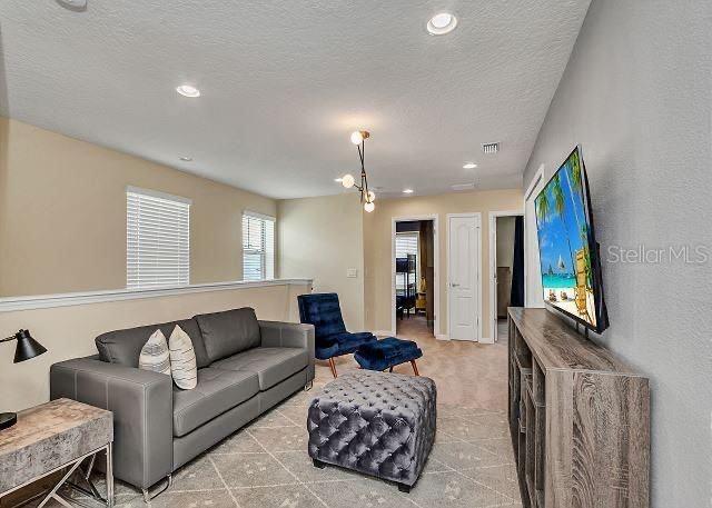 living room with light tile patterned flooring and a textured ceiling