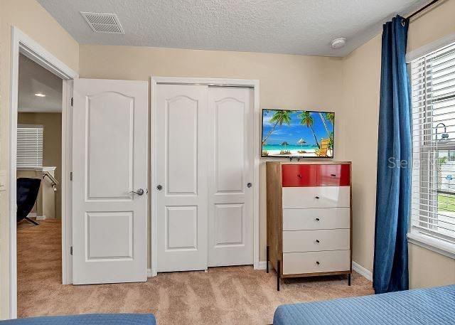 carpeted bedroom featuring a textured ceiling and a closet