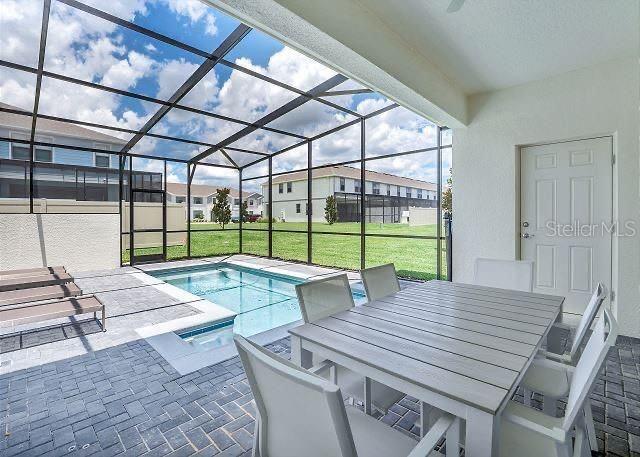 view of pool with a yard, a lanai, and a patio area