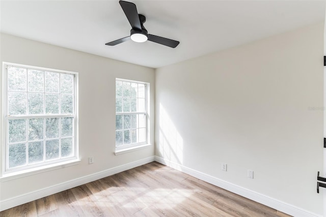 spare room featuring light hardwood / wood-style flooring, a wealth of natural light, and ceiling fan