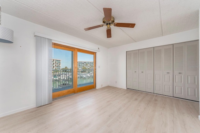 unfurnished bedroom with ceiling fan, access to exterior, a textured ceiling, and light hardwood / wood-style flooring