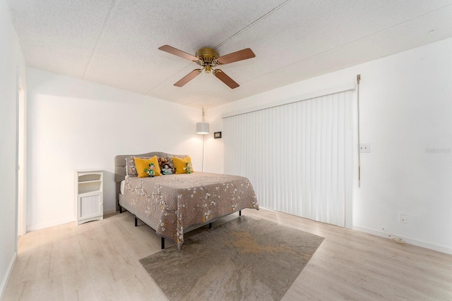 bedroom featuring ceiling fan, a textured ceiling, and light hardwood / wood-style floors