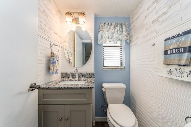 bathroom featuring vanity, toilet, and a textured ceiling